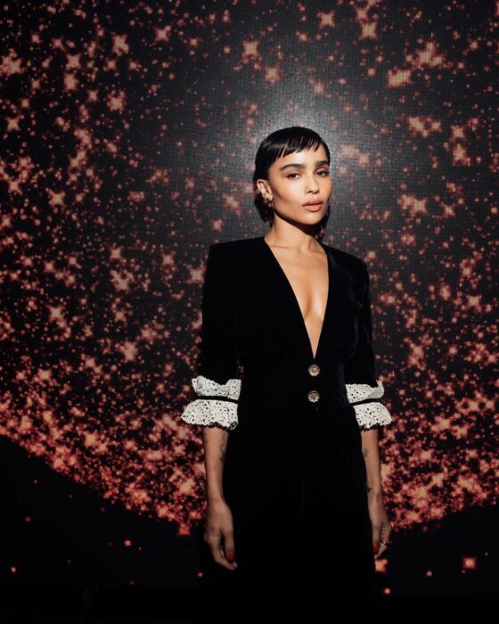 Zoë Kravitz con vestido negro con fondo oscuro 