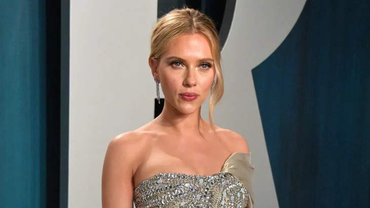 Scarlett Johansson en una alfombra roja de un evento en Hollywood lleva el cabello recogido en un chongo y un elegante vestido de pedrería gris