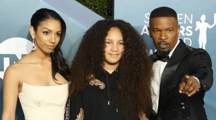 el actor Jamie Foxx en una alfombra roja junto a sus dos hijas