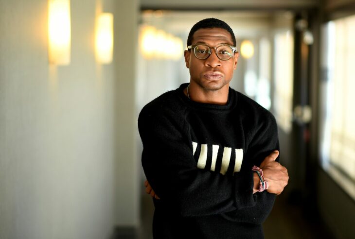 Jonathan Majors cruzado de brazos con camisa negra 