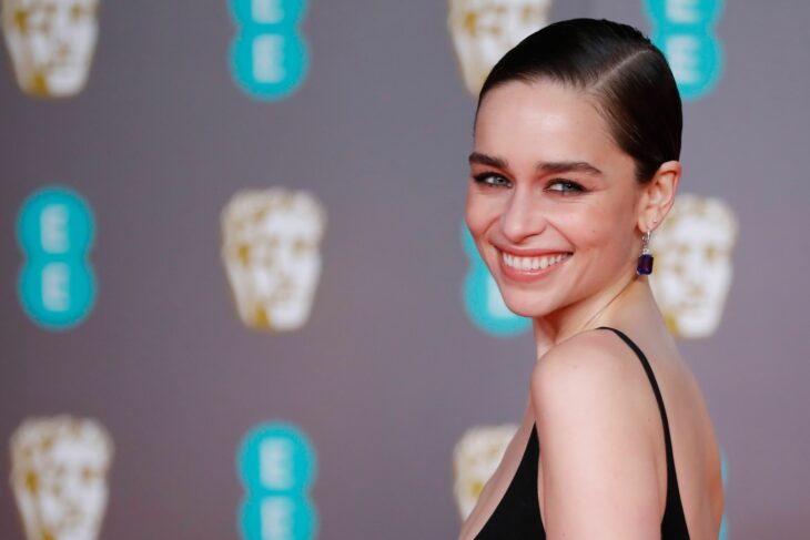 emilia clarke en alfombra roja viendo hacia atrás 