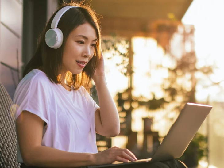 una mujer escucha música mientras trabaja en su computadora