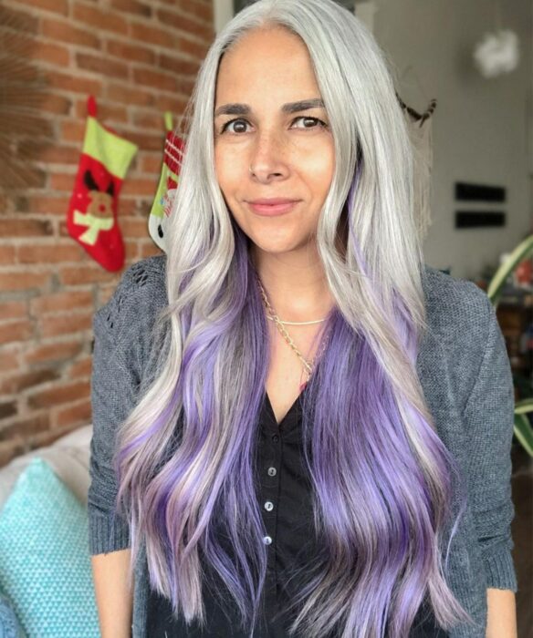 mujer posando con un tono de cabello gris combinado con el morado 