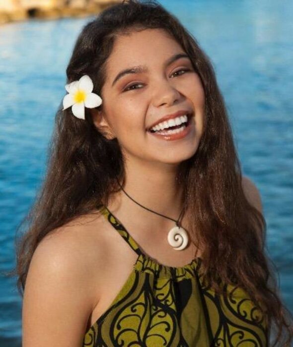 Auli'i Cravalho sonriendo frente a un fondo de mar atrás 