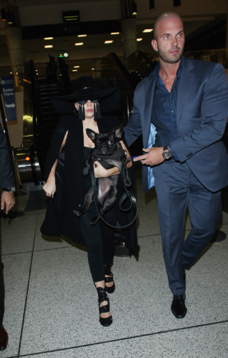 Lady Gaga siendo custodiada por su famoso guardaespaldas lleva un perrito en los brazos 