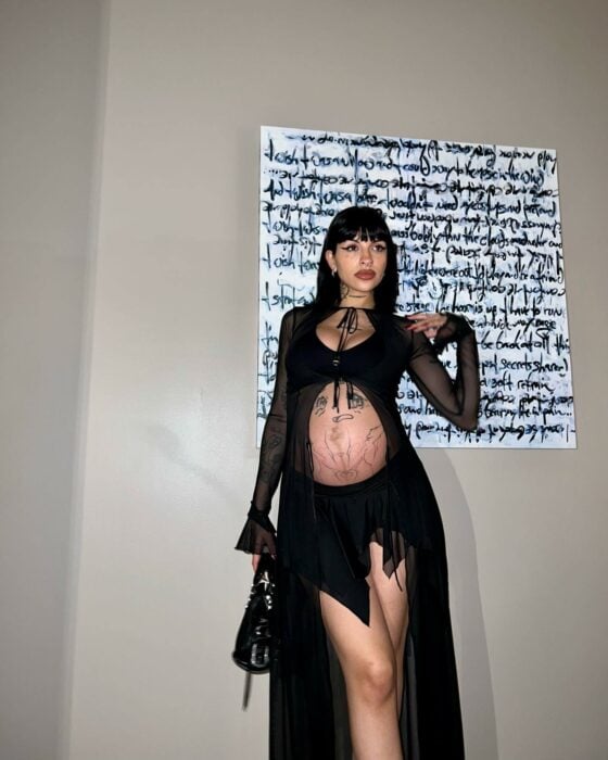 Cazzu posando con un vestido negro de transparencias dejando ver su barriga de embarazo 