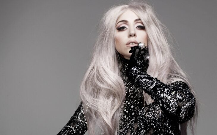 la estrella Lady Gaga posa con un atuendo en negro lleno de pedrería brillosa lleva el cabello e color platinado