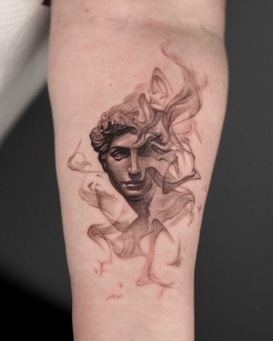 tatuaje con la figura de la estatua de Julián con un poco de humo 