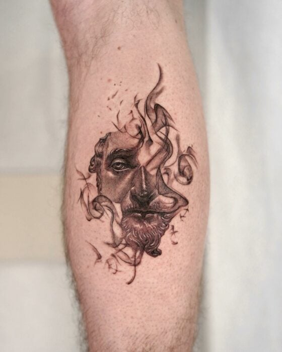 Brazo mostrando un tatuaje con la estatua de Marcus con llamas 