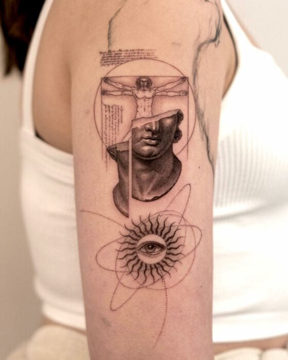 brazo de una persona mostrando un tatuaje con una estatua rota, el sistema solar y el hombre de Vitruvio de Leonardo Da Vinci 
