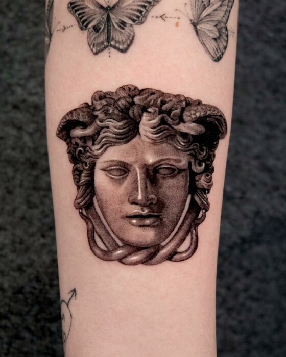 piel con el diseño de un tatuaje con una estatua de medusa 