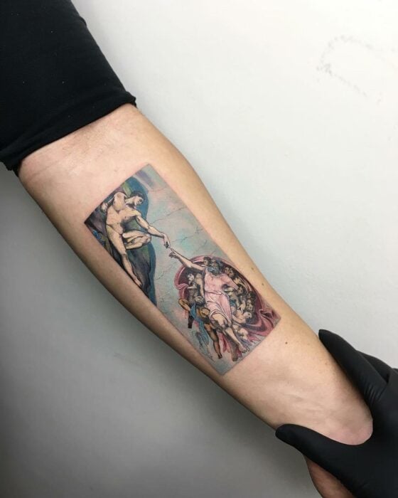 imagen de un brazo con un tatuaje de la creación de Adán de Miguel Ángel 
