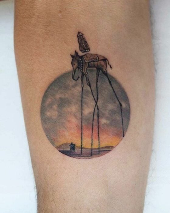 brazo mostrando el tatuaje con la pintura de Los Elefantes de Salvador Dalí 