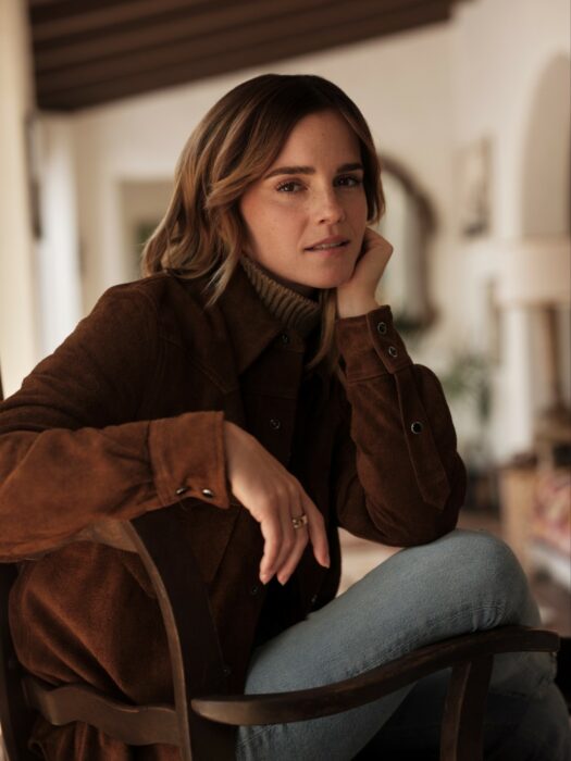 Emma Watson posando sentada en una silla dentro de una casa con viñedos en Francia