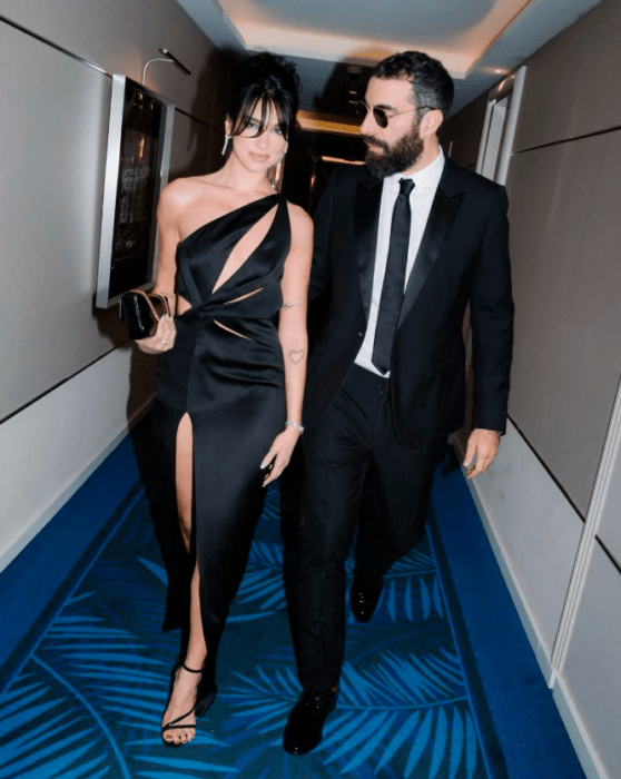 Dua Lipa caminando por un pasillo alfombrado junto a su nuevo novio Romain Gavra 