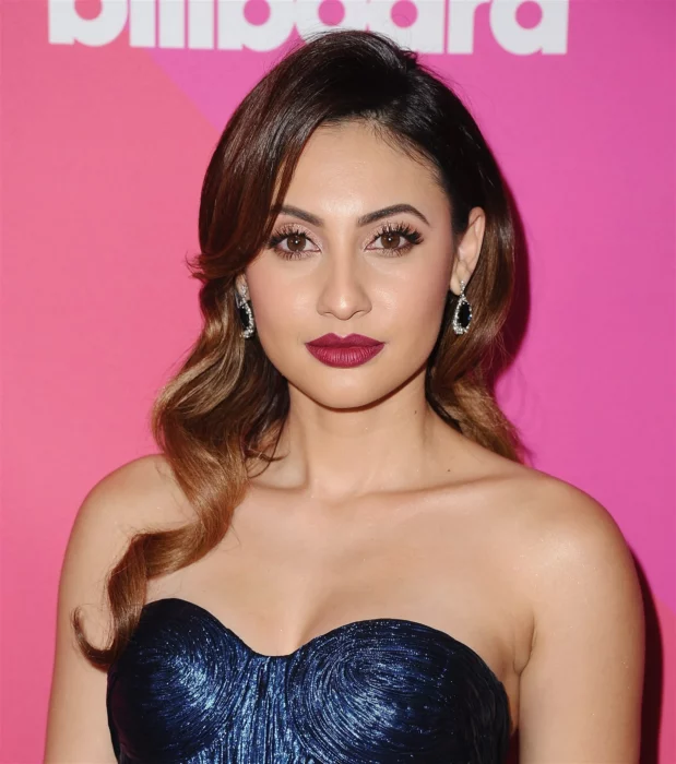 Francia Raisa poses on the red carpet of an event in Hollywood wearing an off-the-shoulder dress and her hair down