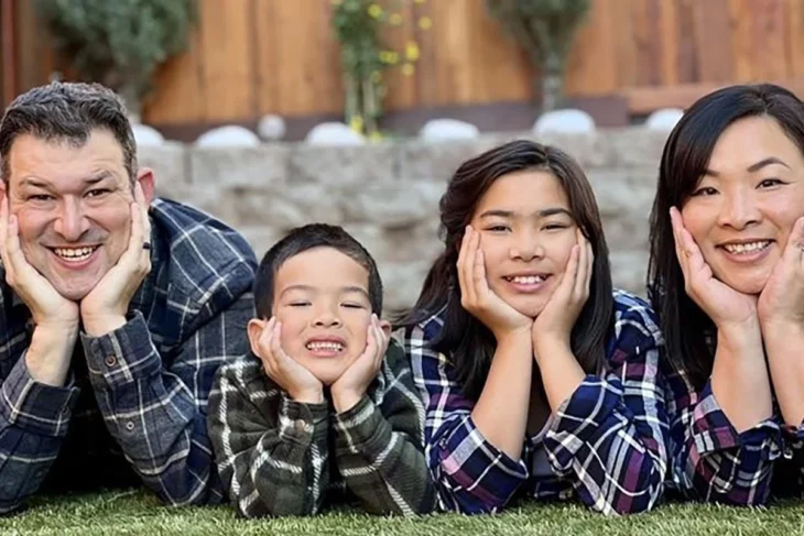 una familia de cuatro miembros con ascendencia asiática posan divertidos en una imagen