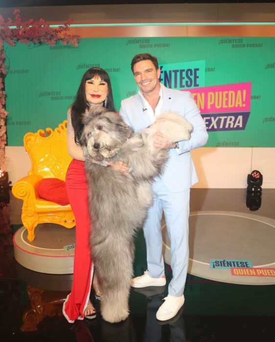 Lyn May posing with a dog next to the driver Julián Gil 