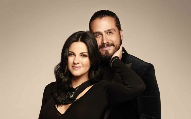 Maite Perroni y Andrés Tovar posan vestidos de negro con una discreta sonrisa en el rostro 