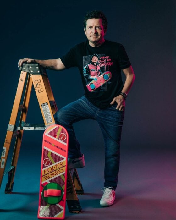 Michael J. Fox posando con una escalera y una patineta al estilo de la película Volver al futuro 