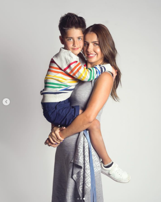 Michelle Renaud trae cargando a su hijo en brazos mientras posan para la cámara
