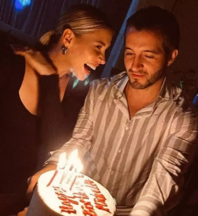 celebrando un cumpleaños junto a un pastel con velitas encendidas esta Michel Salas junto a su pareja