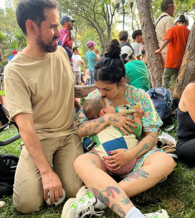 Mon Laferte cargando a su hijo al lado de su pareja Joel Orta 