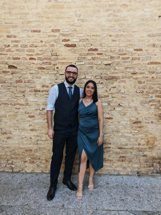 Fotografía de una chica posando en vestido al lado de un hombre vestido de traje 