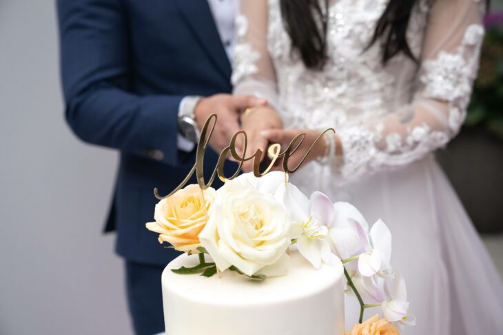 pareja de esposos partiendo su pastel de bodas 