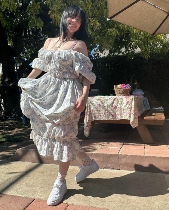 Billie Eilish con vestido y tenis al aire libre 