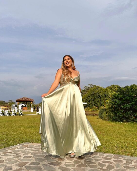 Jessi Rodriguez con vestido largo en un jardín 