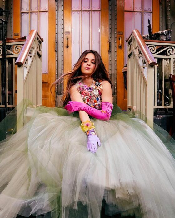 Camila Cabello con vestido de tul sentada en una escalinata 