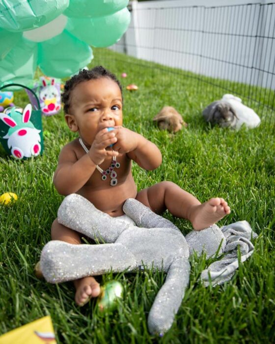 Bebé de Rihanna sentado en el césped entre huevos de Pascua