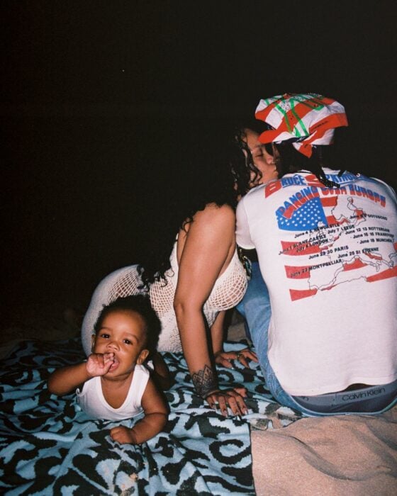 Rihanna dando un beso en la mejilla a a y A$AP Rocky con su hijo RZA en un lado 