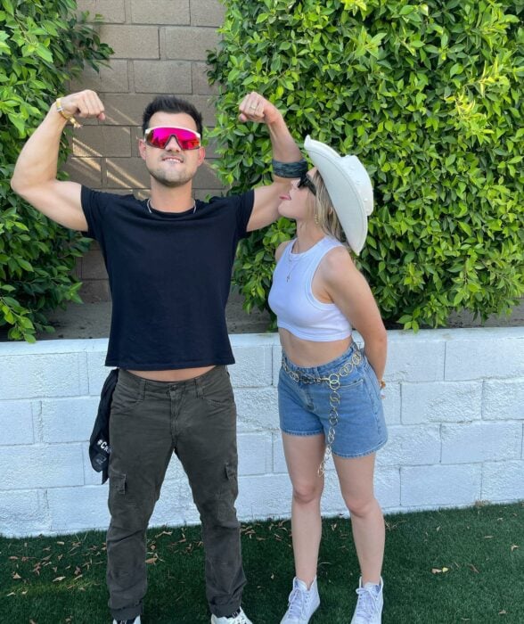 Taylor Lautner posando con los brazos arriba al lado de su esposa Taylor Dome 