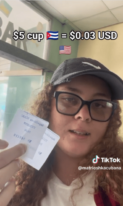 una chica con gorra y lentes muestra los tickets de entrada al cine