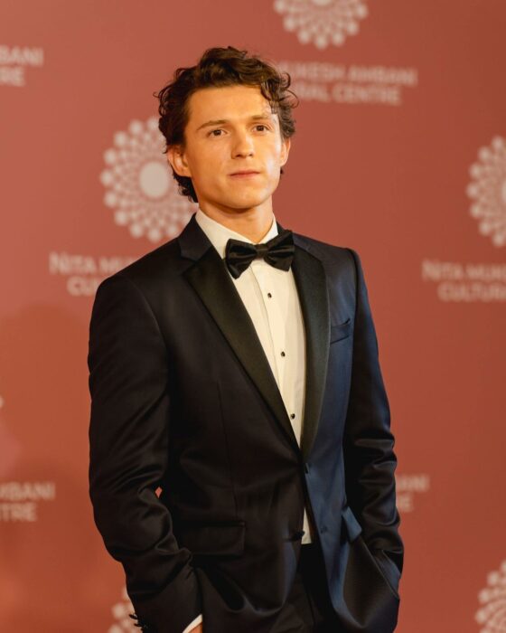 Tom Holland posando con esmoquin en una alfombra roja 