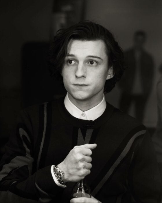 Fotografía de Tom Holland en blanco y negro con una botella de vidrio en su mano