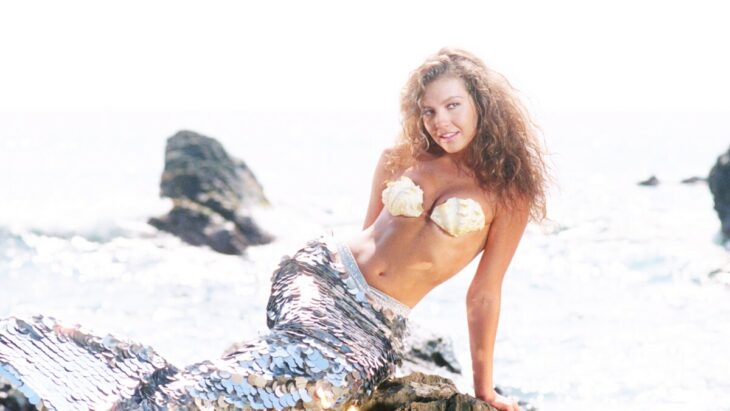 Thalía sentada en una piedra como si fuera sirena 