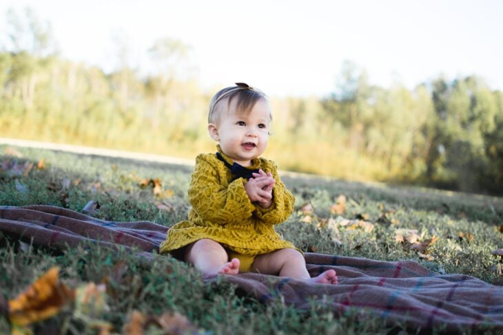 bebé sentada en un jardín 