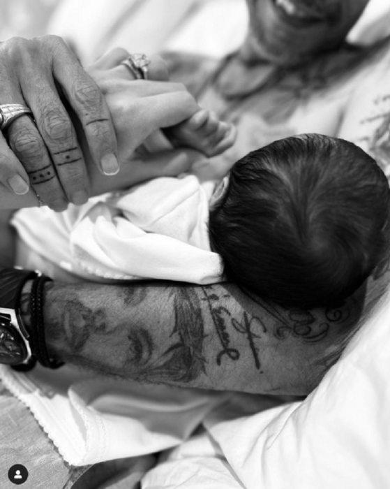Marc Anthony and Nadia Ferreira's first baby forum, the singer holds his son in his arms, bare-chested and with one hand he takes Nadia's hand, who in turn holds the little one's hand