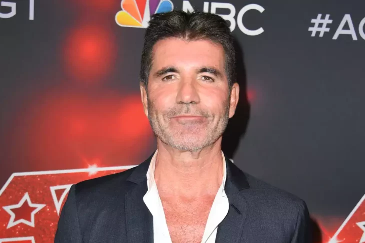 Simón Cowell posa en la alfombra roja de algún evento de la NBC lleva saco y camisa sin corbata