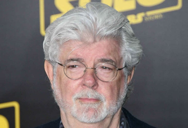 George Lucas mira a un lado mientras le tomaron la fotografía lleva anteojos con aros circulares