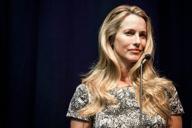 Laurene Powell esta de pie atrás de un micrófono es una mujer caucásica de cabello largo