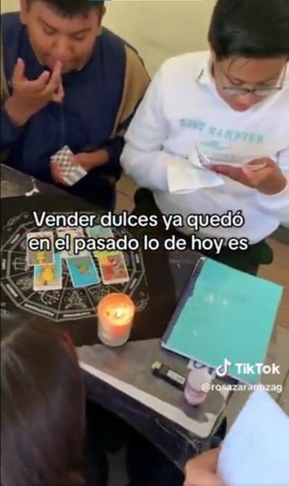 captura de pantalla de un par de chicos leyendo las cartas del tarot en un salón de clases 