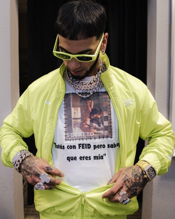 Fotografía de Anuel AA mostrando una camisa con un estampado y frase de Karol G asegurando que es suya aunque este de novia de Ferxxo