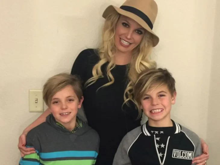 Britney Spears con sus hijos cuando eran más pequeños todos están sonrientes ella lleva un sombrero café