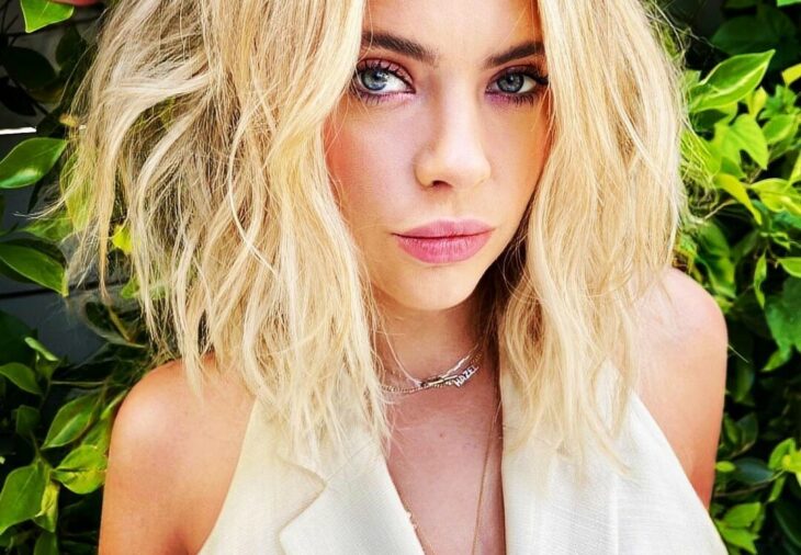 Ashley Benson mira directamente a la cámara con el cabello despeinado en un tono rubio lleva maquillaje 