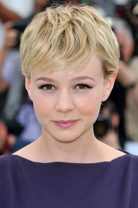 Carey Mulligan con el cabello rubio super cortito mira a la cámara