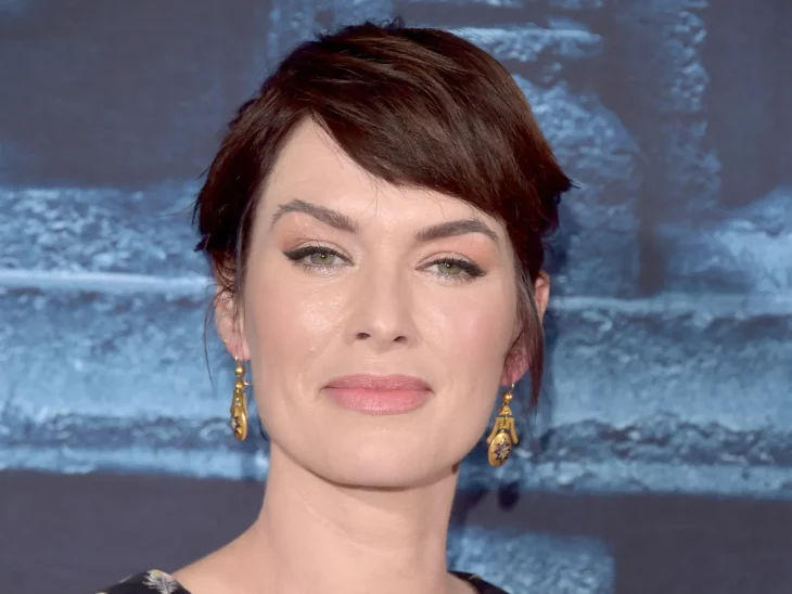 Lena Headey posa con seguridad ante la cámara está peinada con un chongo y lleva pendientes dorados